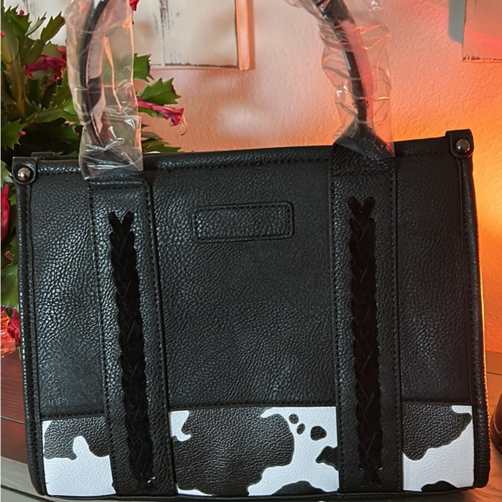 Adorable black purse with cow print designed bottom.